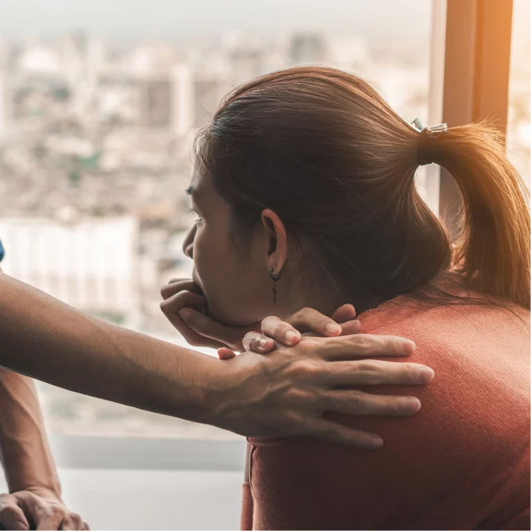 Person with a hand on their shoulder.