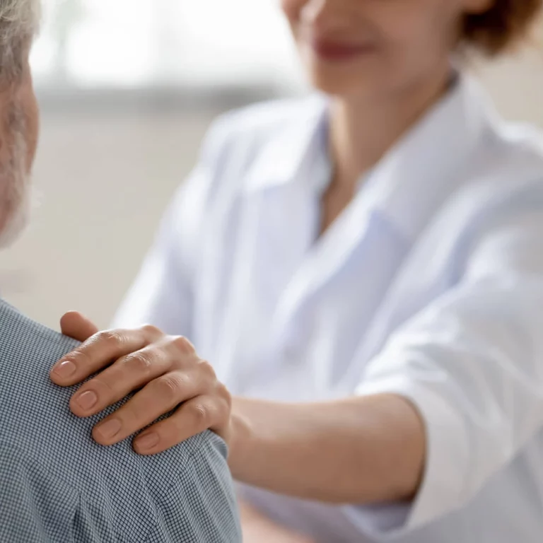 Person with a hand on anothers shoulder