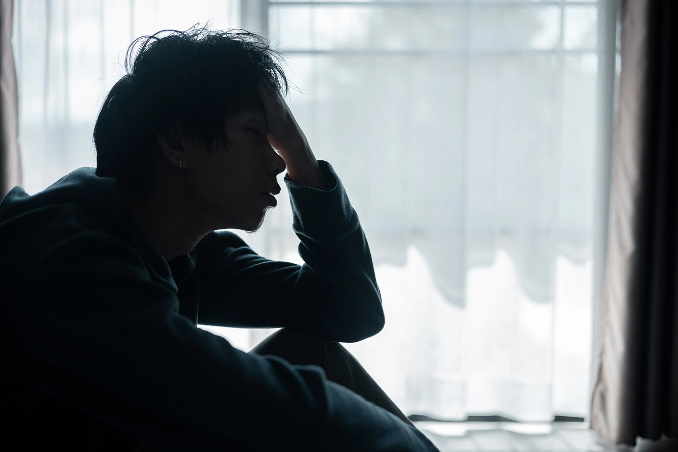 Person sitting in front of a window.